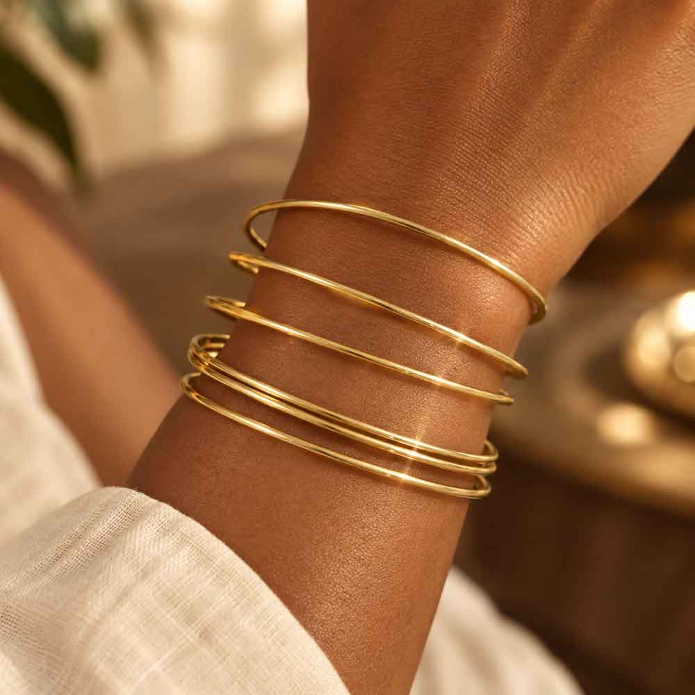 Model wearing 6 gold skinny stackable bangles - Lilylin Designs