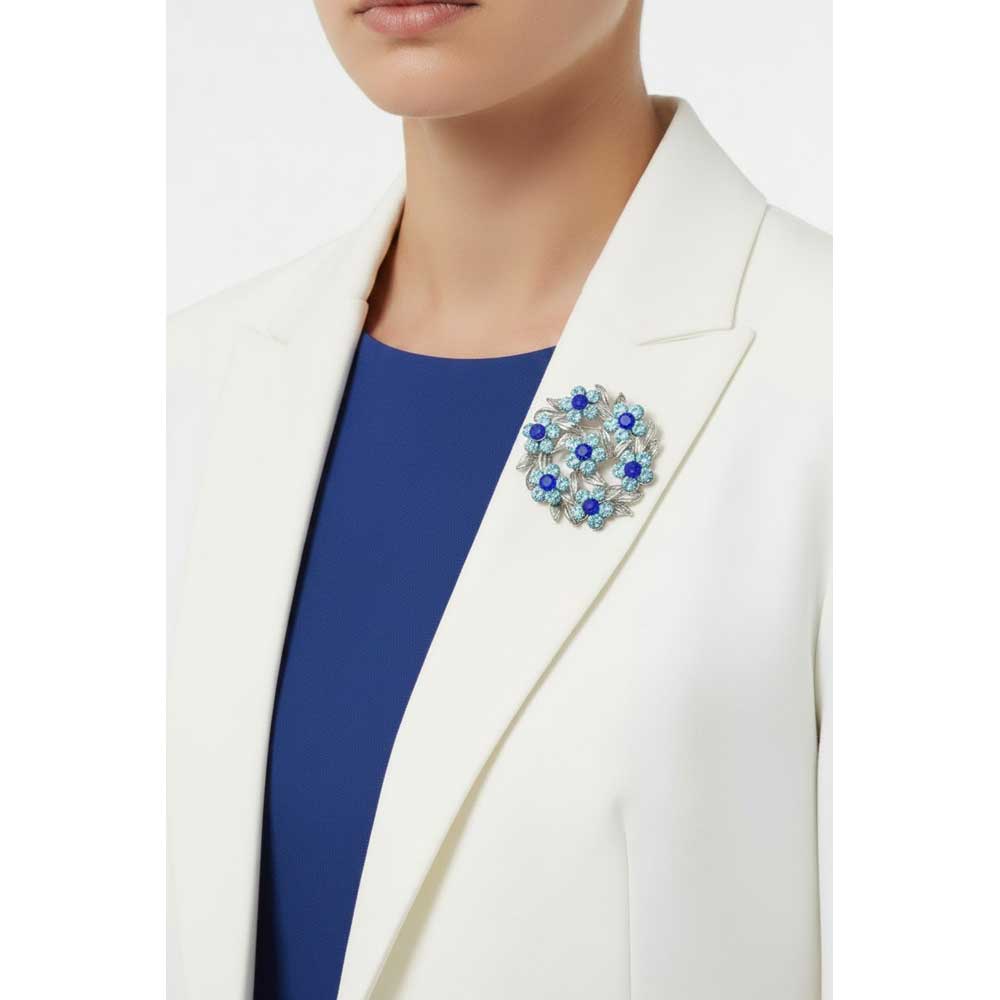 Model wearing dark and light blue daisies wreath pin on a white jacket - Lilylin Designs