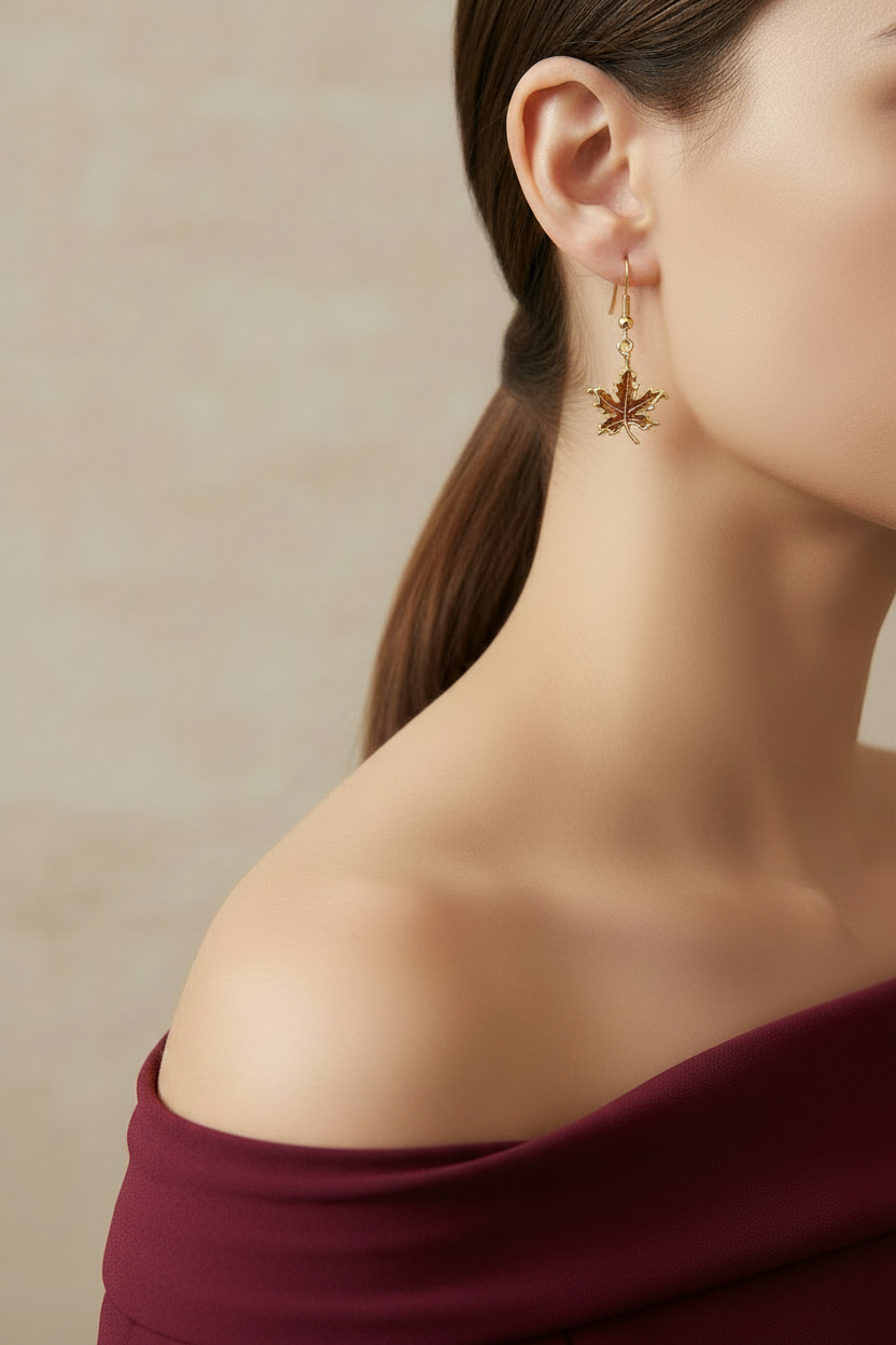 Model wearing gold enamel maple leaf dangling earring - Lilylin Designs