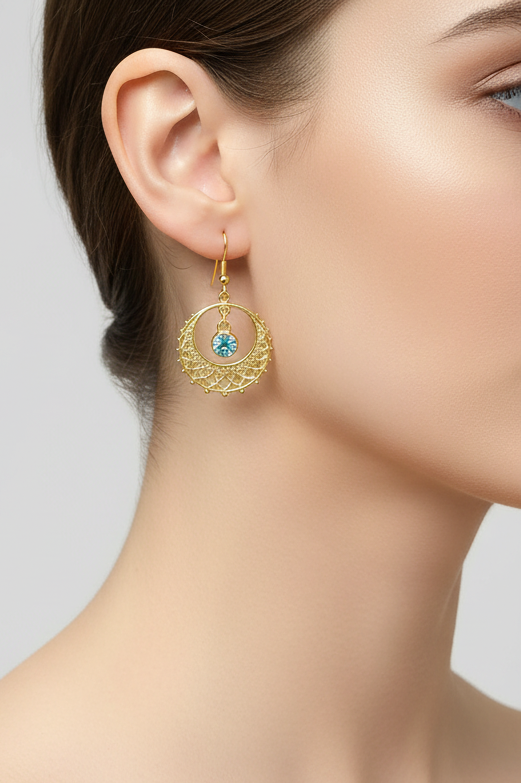 Model wearing gold filigree earring with blue crystal - Lilylin Designs