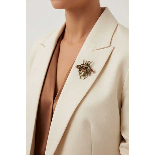 Model wearing Antique brown crystal fly brooch pin on a cream jacket with a brown top - Lilylin Designs