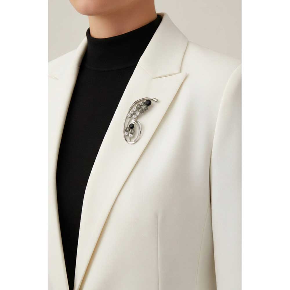 Model wearing Black and gray crystal flower brooch pin on a white jacket with a black turtleneck - Lilylin Designs