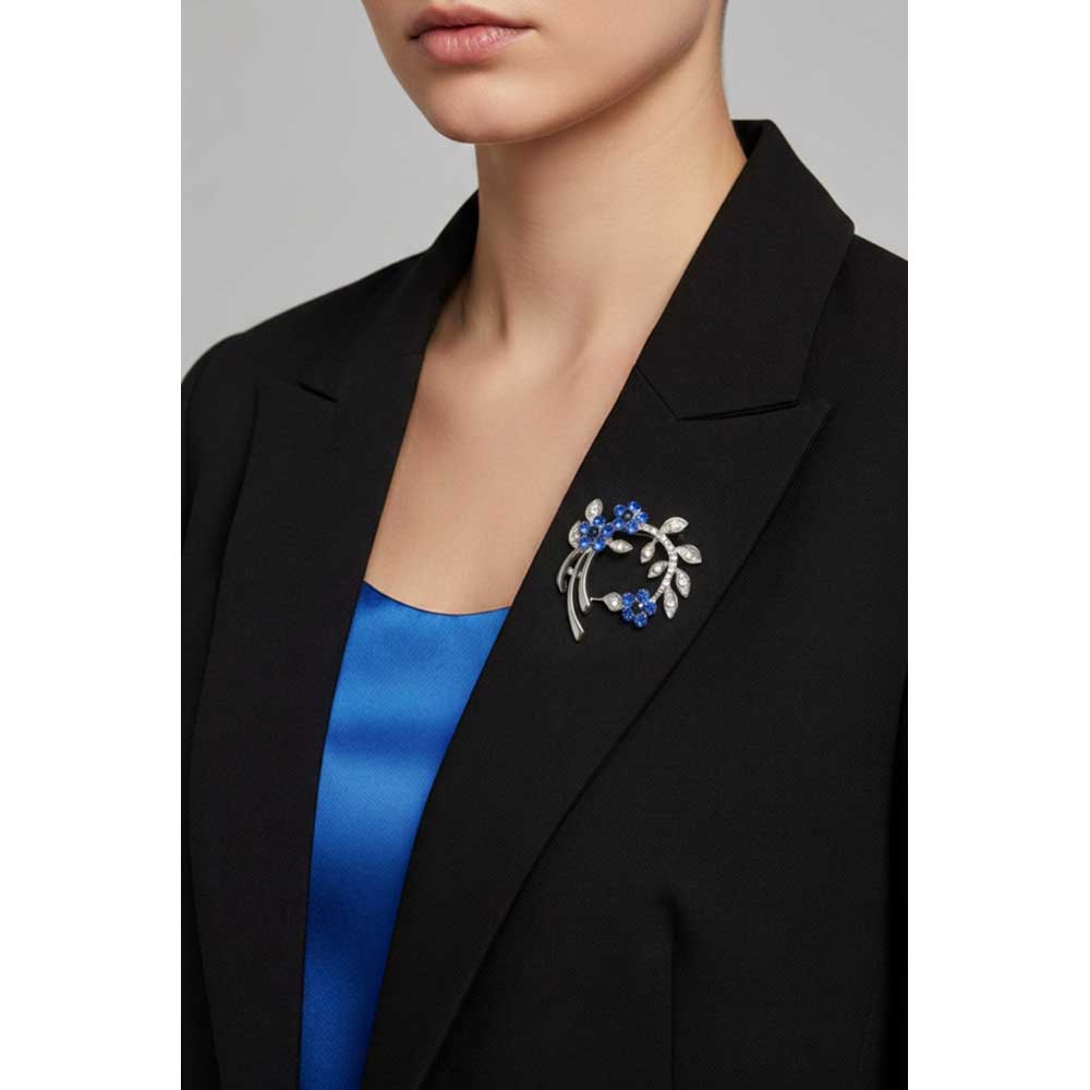 Model wearing Curved branch with blue flowers brooch pin on a black jacket with a blue shirt - Lilylin Designs