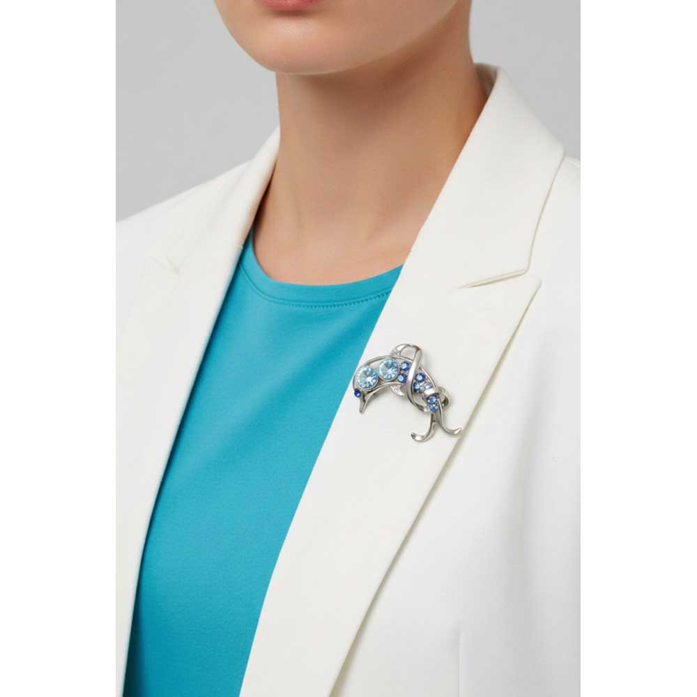 Model wearing Dolphin with large blue stones brooch pin on a white jacket with a blue top - Lilylin Designs
