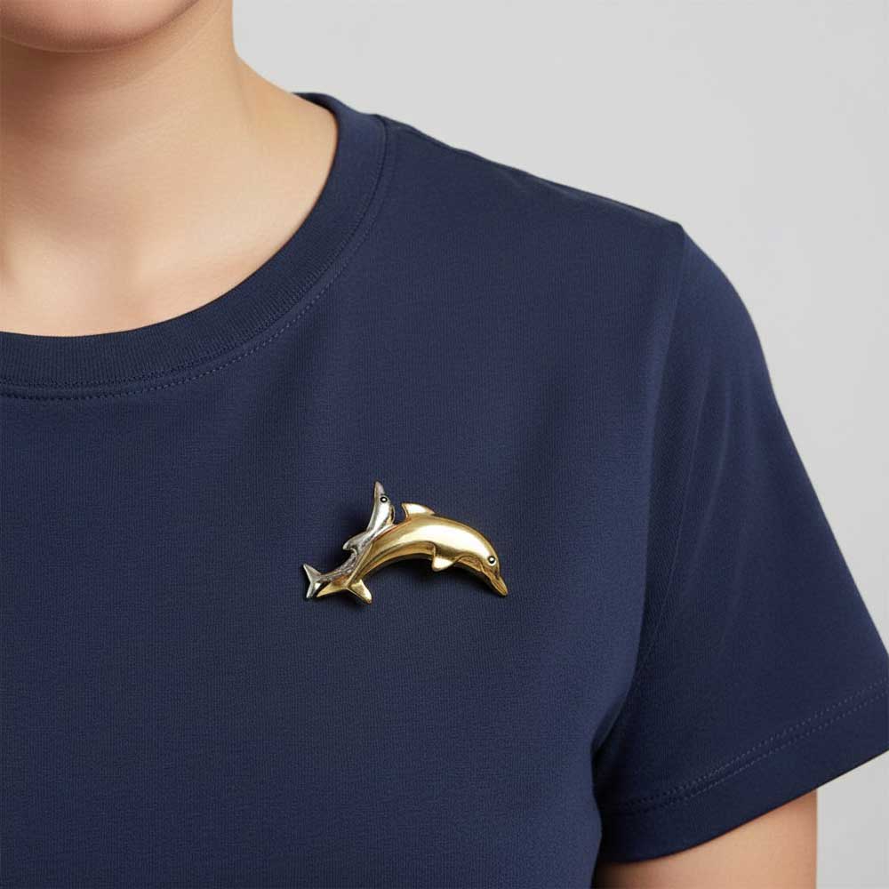 Model wearing Gold and silver dolphins brooch pin on a blue t-shirt - Lilylin Designs