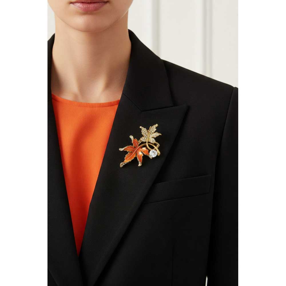 Model wearing Orange and gold maple leaves brooch pin on a black jacket with an orange top - Lilylin Designs
