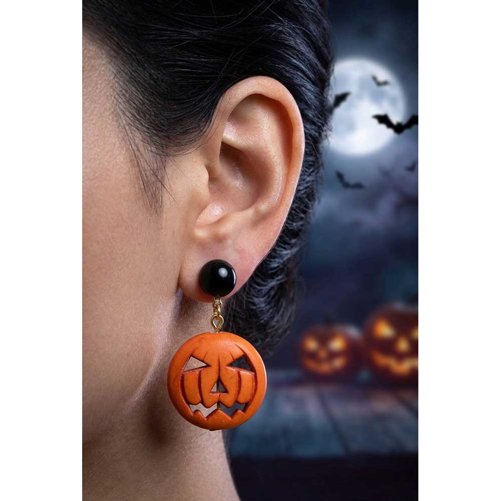 Closeup of model wearing black and orange jack o lantern earrings with a Halloween background - Lilylin Designs