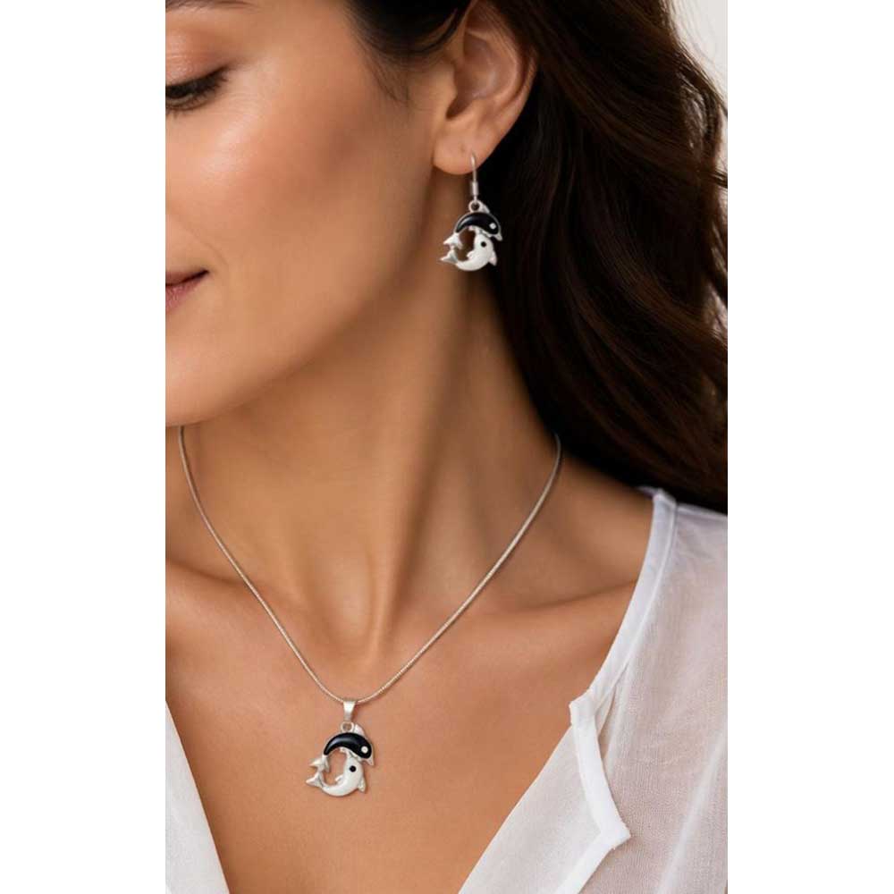 Model wearing black and white dolphin necklace and earring set with a white top - Lilylin Designs