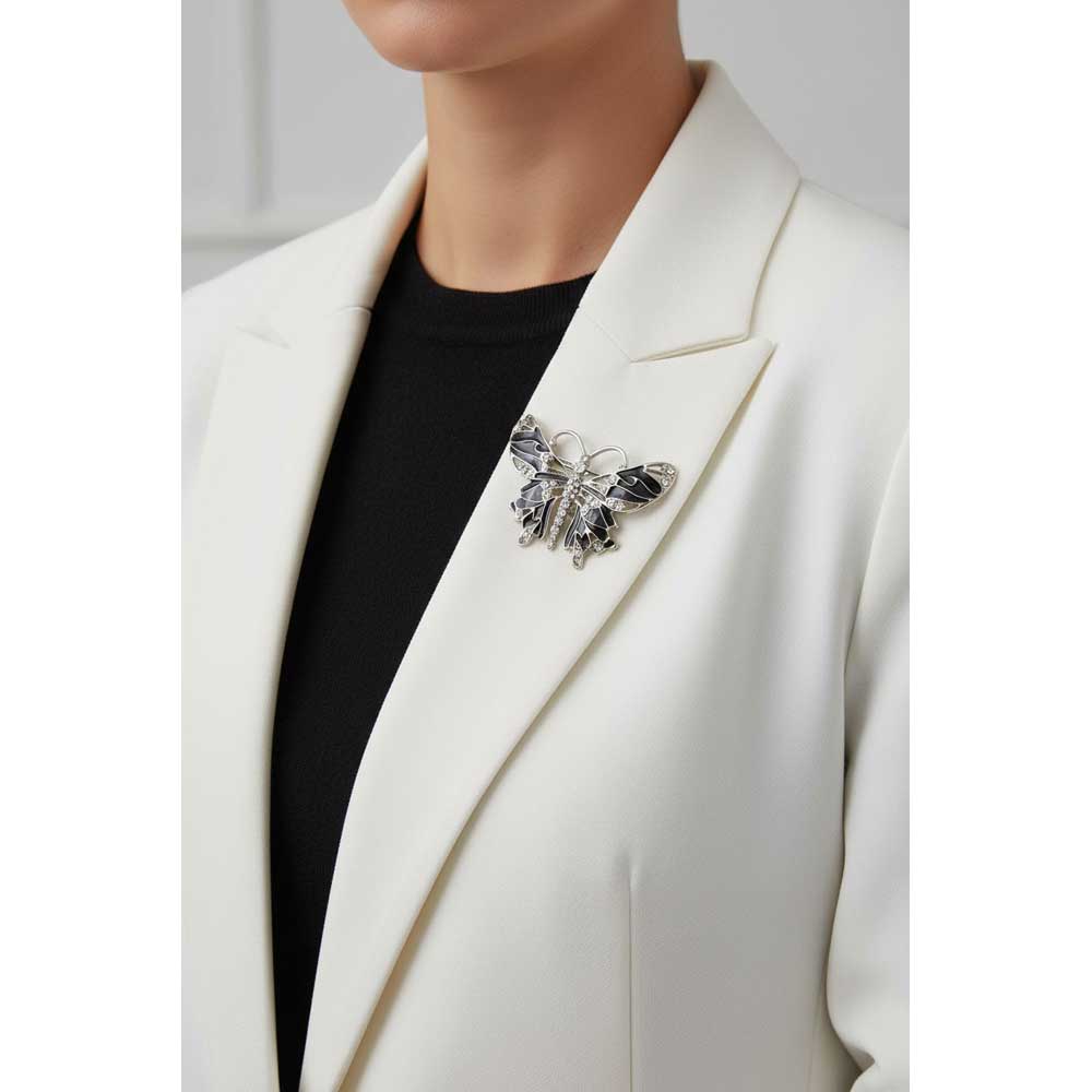 Model wearing a black butterfly brooch pin on a white jacket with black top - Lilylin Designs