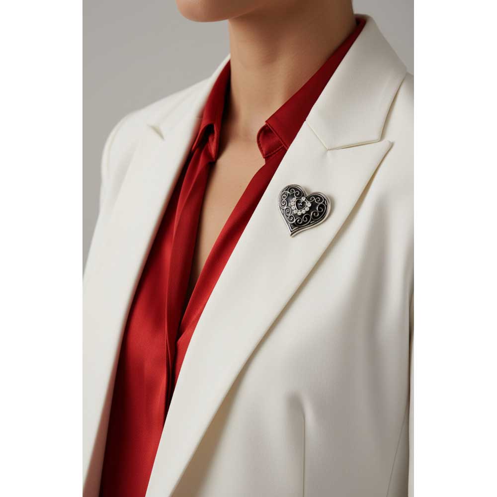 Model wearing black enamel heart brooch pin on a white jacket with a red top - Lilylin Designs