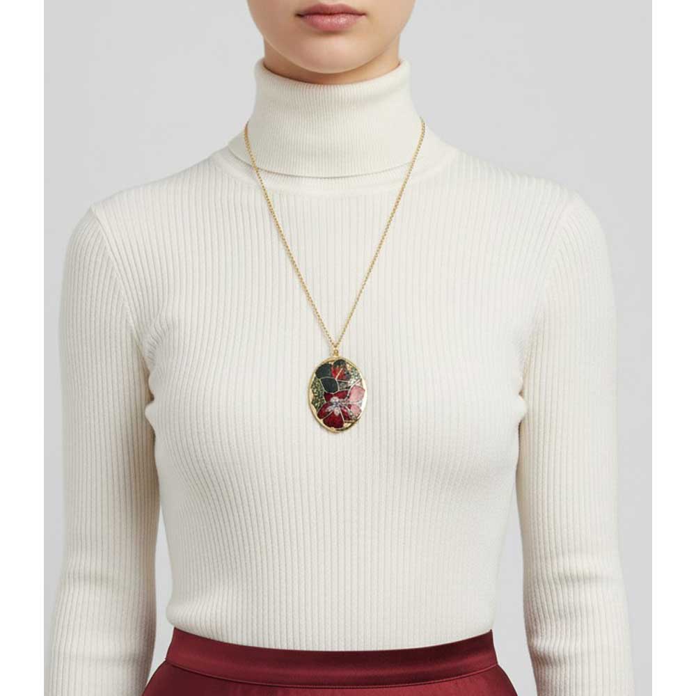 Model wearing Lilylin Designs cloisonne hibiscus necklace with a white turtle neck and red skirt