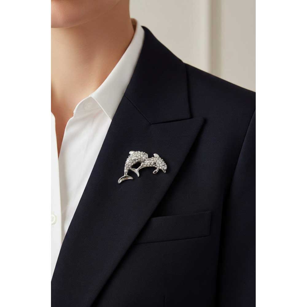 Model wearing small silver crystal dolphins brooch pin on a black jacket with a white shirt - Lilylin Designs