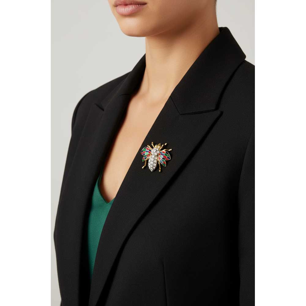 Model wearing crystal fly brooch pin on a black jacket with a green top - Lilylin Designs