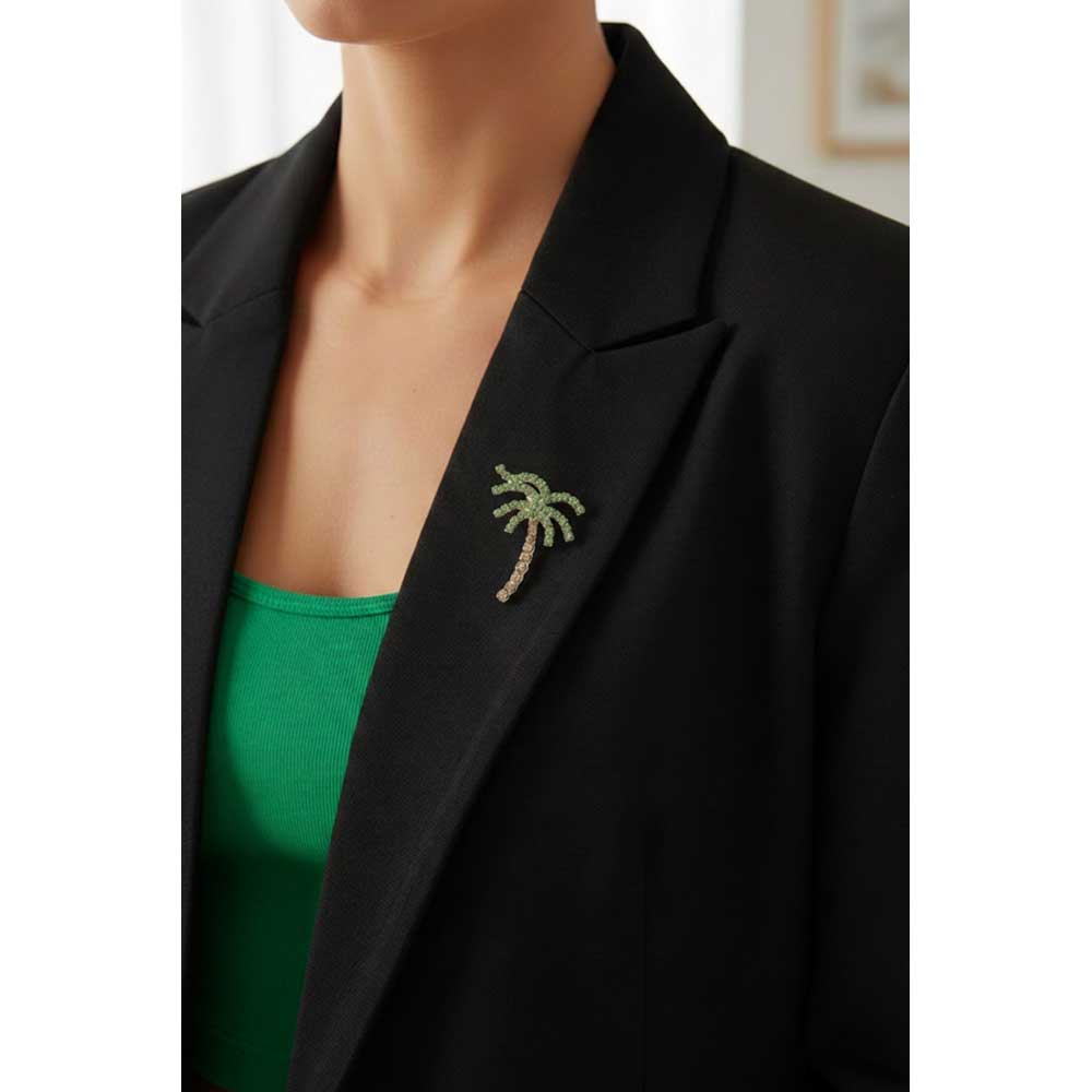 Model wearing Crystal palm tree brooch pin on a black jacket with a green top - Lilylin Designs