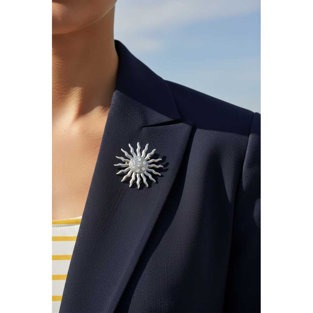 Model wearing crystal sun brooch pin on a navy blue jacket with white and yellow top - Lilylin Designs