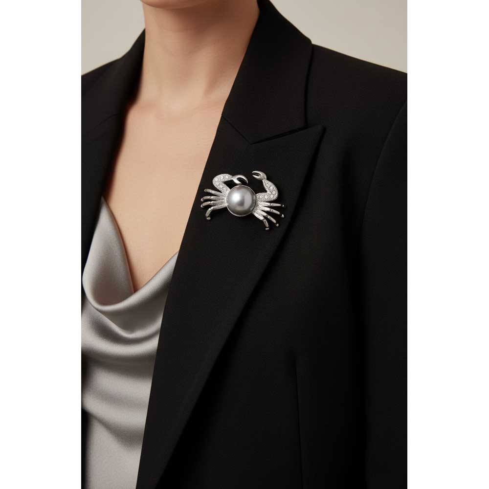 Model wearing gray pearl crab brooch pin on a black jacket with a gray top - Lilylin Designs