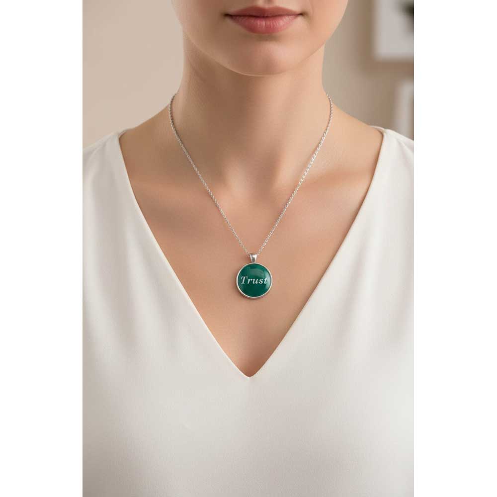 Model wearing Lilylin Designs green with white "Trust" necklace with a white dress
