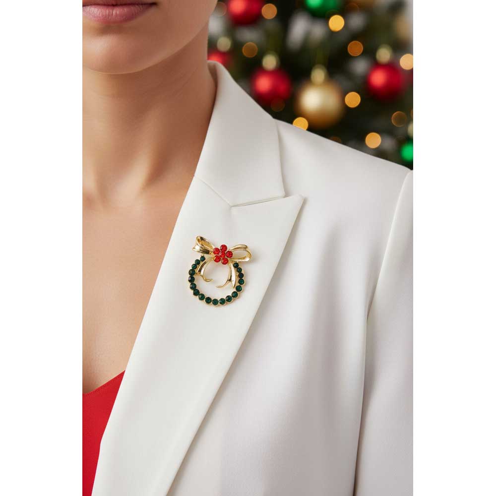 Model wearing green wreath with red daisy brooch pin on a white jacket with a holiday themed background - Lilylin Designs