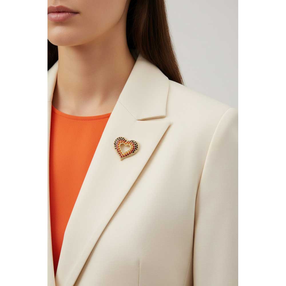 Model wearing red orange and dark orange crystal heart brooch on a cream jacket with an orange top - Lilylin Designs