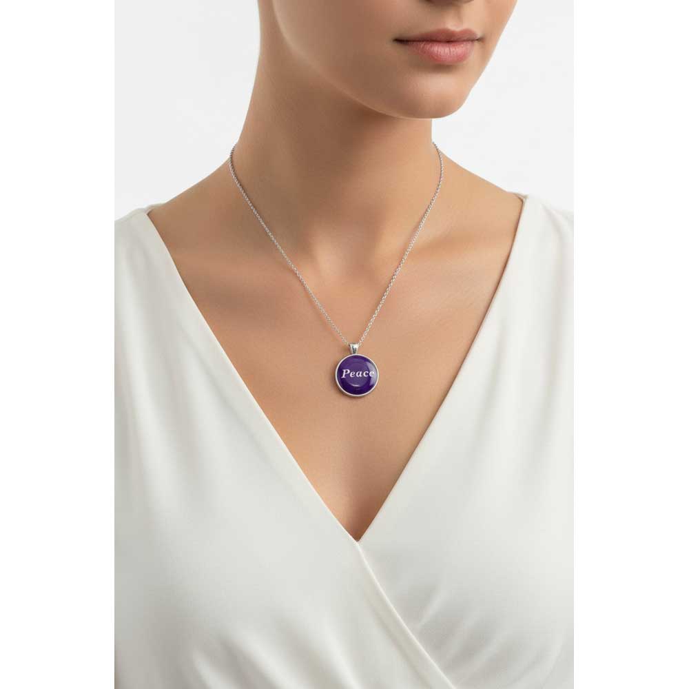Model wearing Lilylin Designs handcrafted purple with "Peace" in white with a white dress