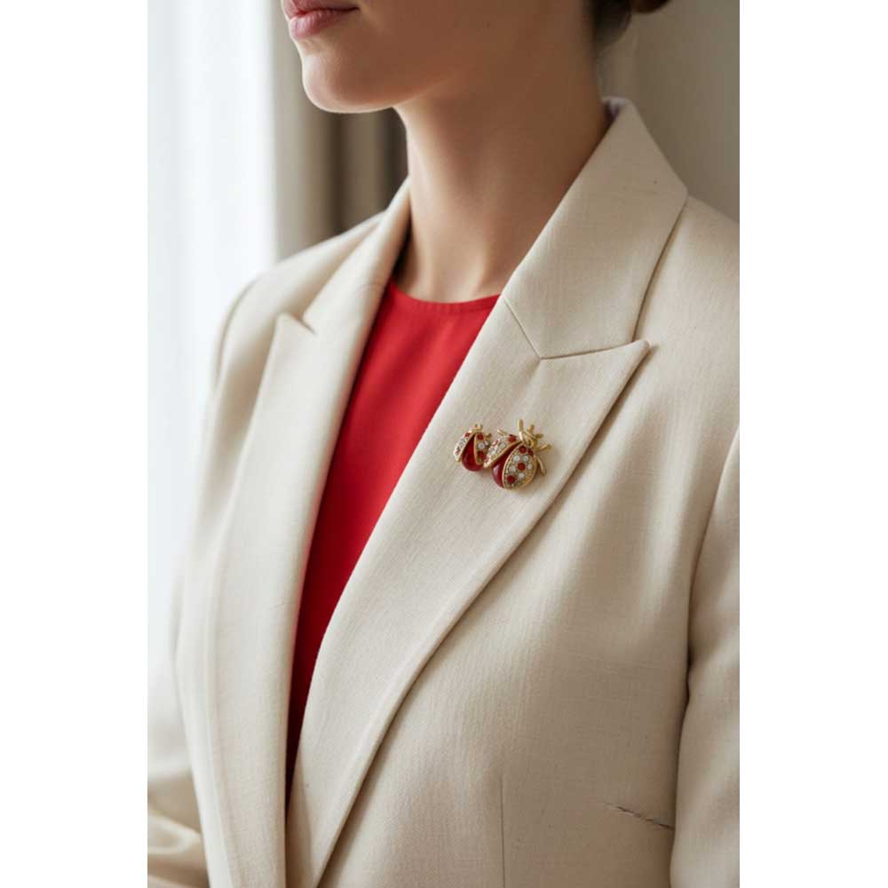 Model wearing red crystal mom and baby ladybug brooch pin on a cream jacket with a red top - Lilylin Designs