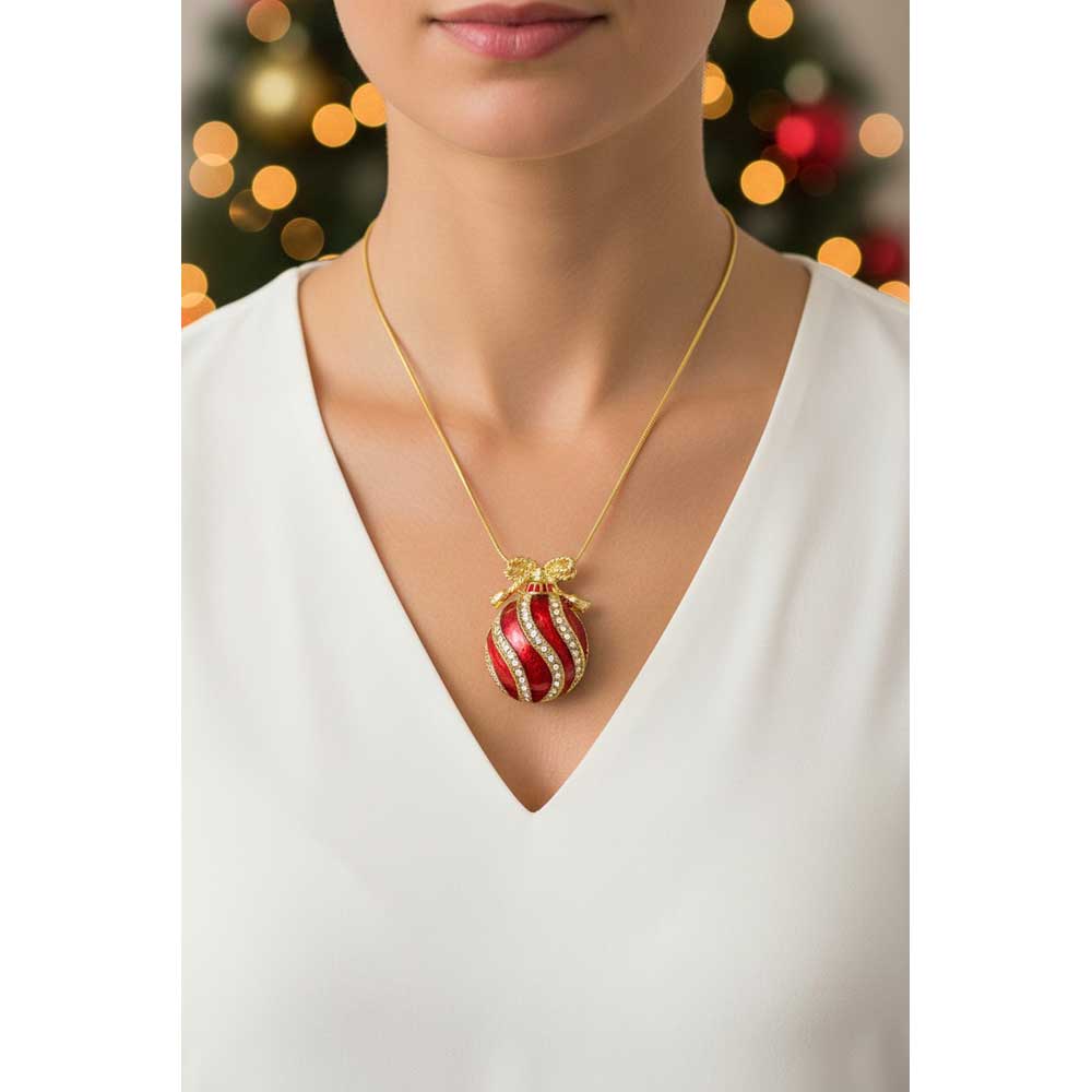 Model wearing red ornament necklace with a white v neck top with blurred Christmas lights background - Lilylin Designs