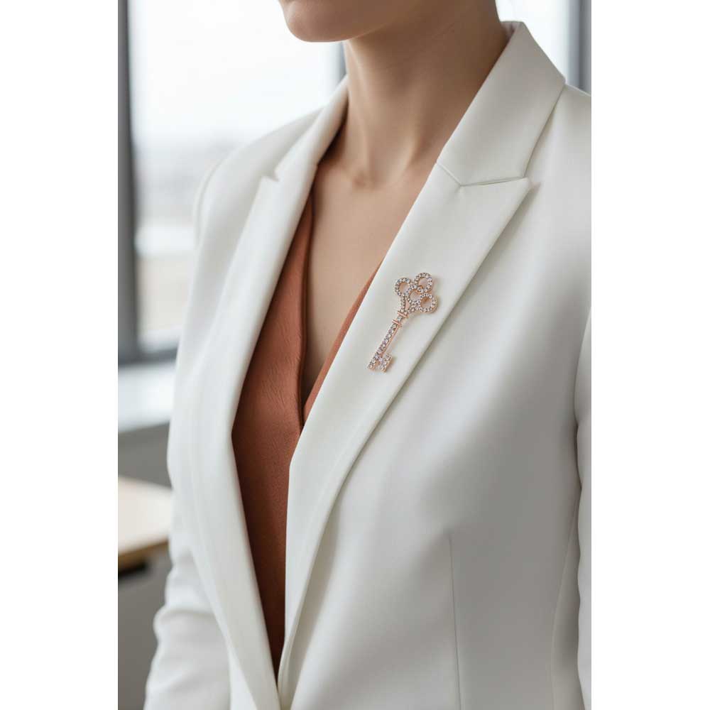 Model wearing rose gold crystal key brooch pin on a white jacket - Lilylin Designs