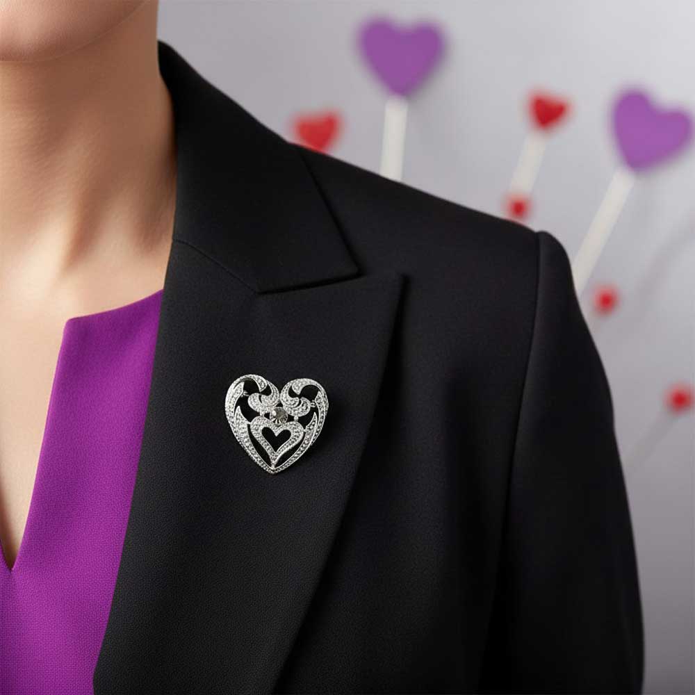 Model wearing silver heart with gray crystal brooch pin on a black jacket with a purple top - Lilylin Designs