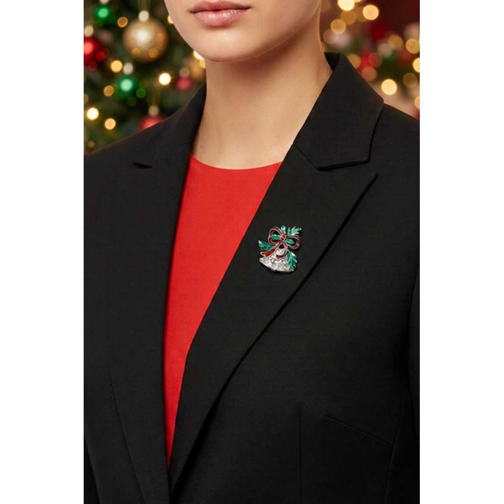 Model wearing small Christmas silver bells lapel tac pin on a black jacket with a red top in front of a blurred Christmas tree  - Lilylin Designs