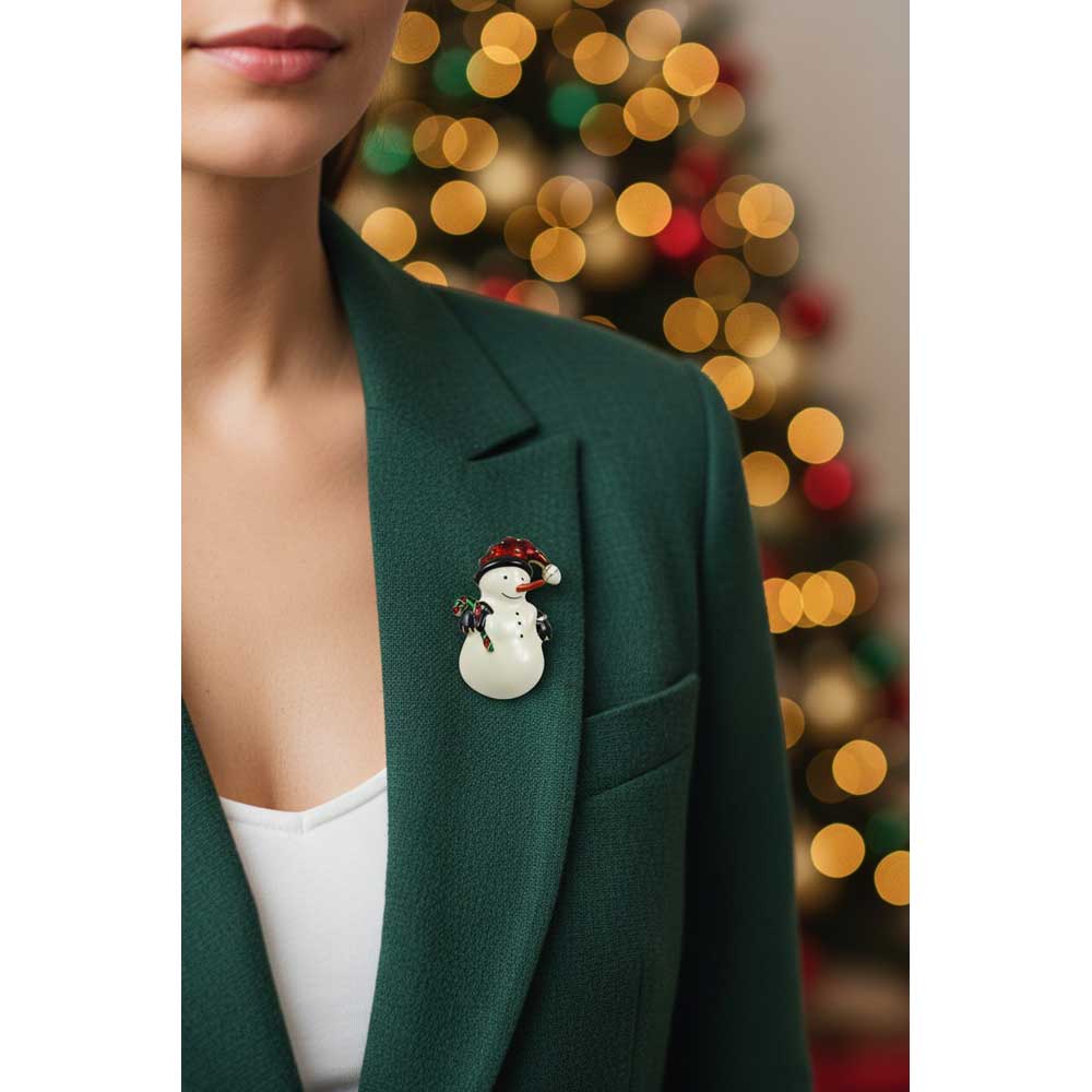 Model wearing snowman with carrot nose brooch pin on a green jacket with blurred holiday background - Lilylin Designs