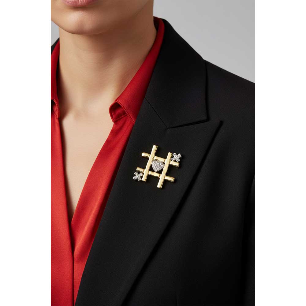 Model wearing gold and crystal tic tac toe heart and x brooch pin on a black jacket - Lilylin Designs
