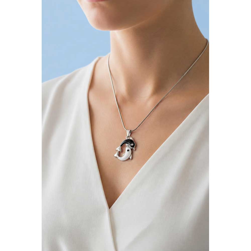 Model wearing black and white dolphin necklace with a white shirt and blue background - Lilylin Designs