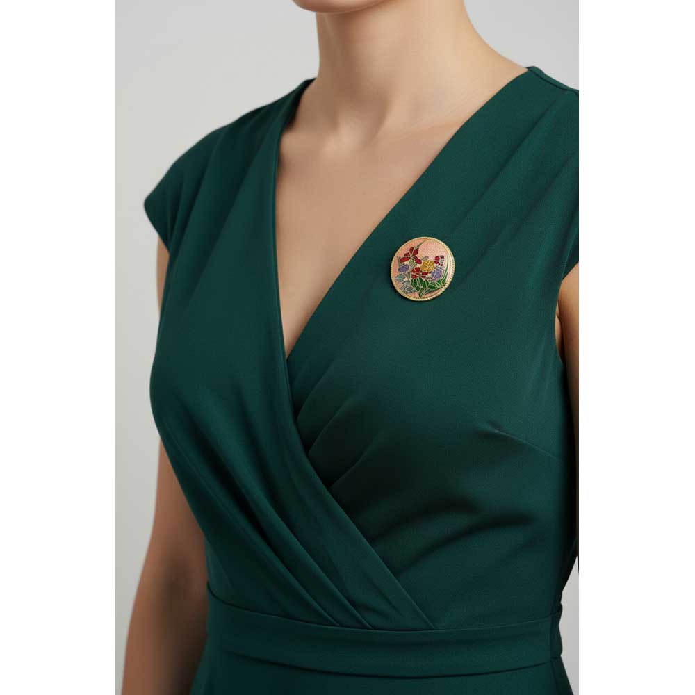 Model wearing peach cloisonne flower brooch on a green dress - Lilylin Designs