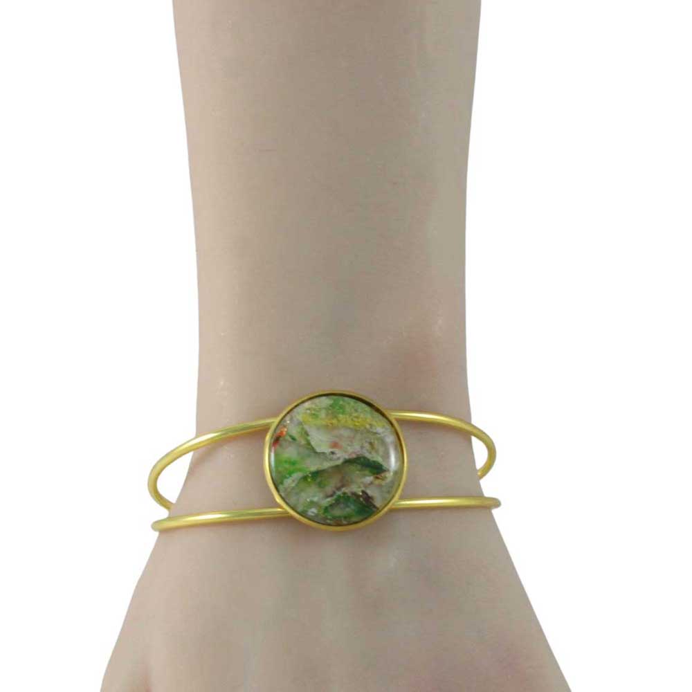 Gold bracelet with a green circular stone on a wrist against a white background | Lilylin Designs