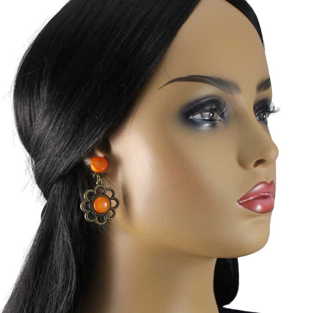 Model with air of earrings with orange round resin and floral daisy bronze frames on a white background - Lilylin Designs