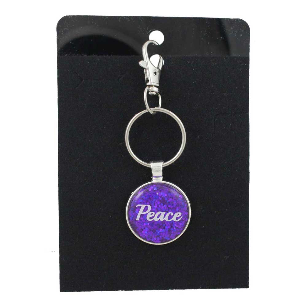Keychain with 'Peace' on a purple glittery background, displayed on a black card - Lilylin Designs