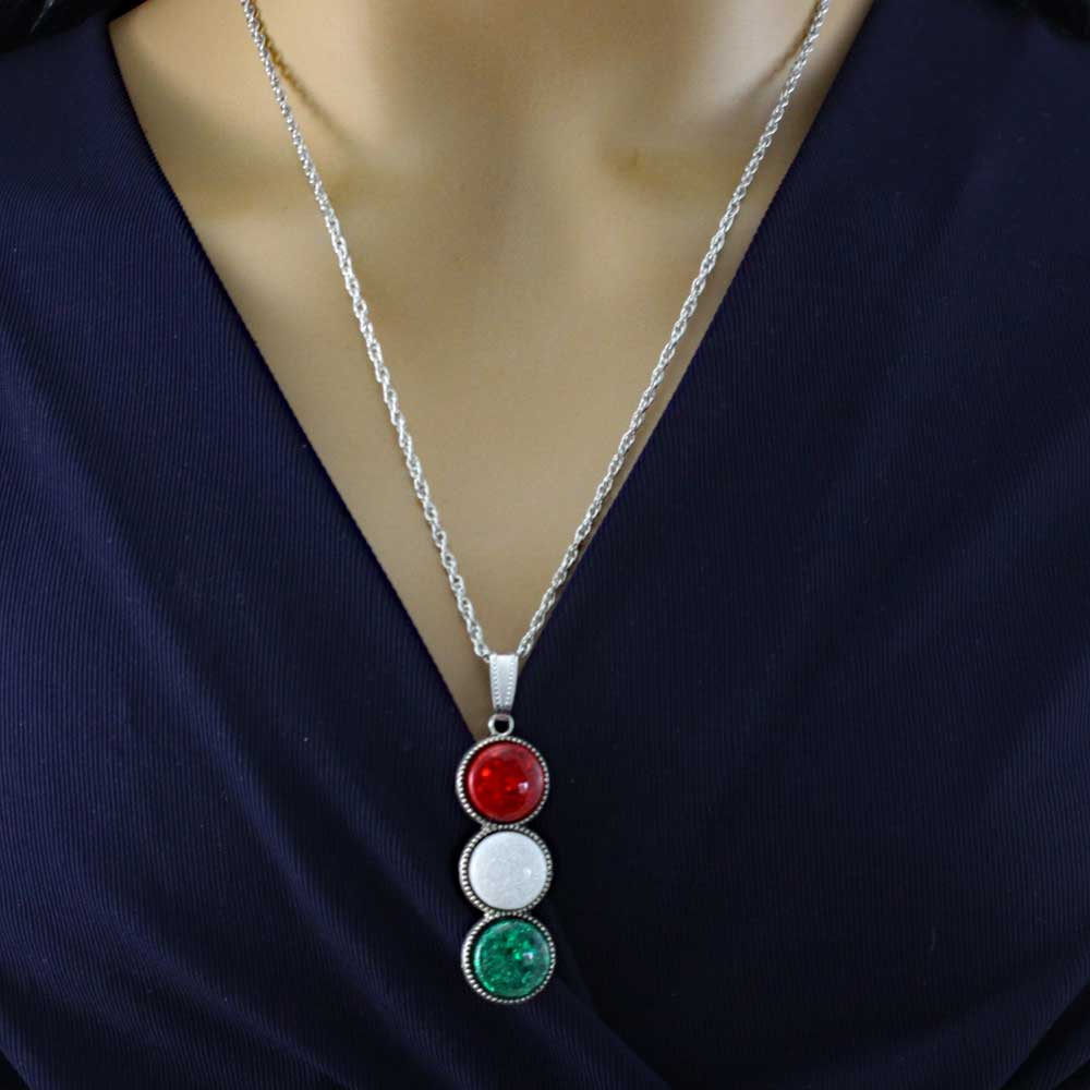 Necklace with red, white, and green pendant on a model wearing a dark blue  top - Lilylin Designs