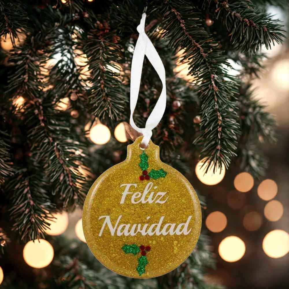 Gold glittery ornament with 'Feliz Navidad' text hanging on a Christmas tree | Lilylin Designs