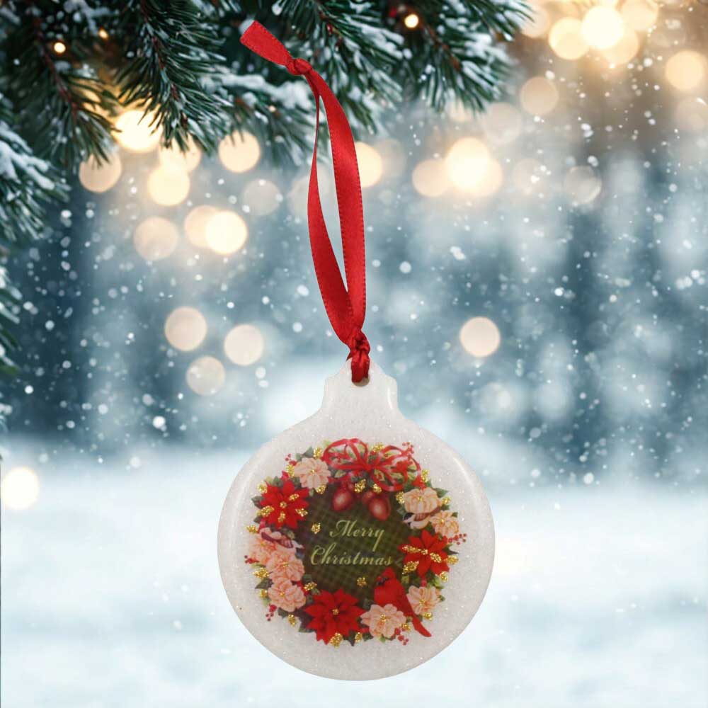 Christmas ornament with floral design and 'Merry Christmas' text, hanging from a tree branch with a snowy background | Lilylin Designs