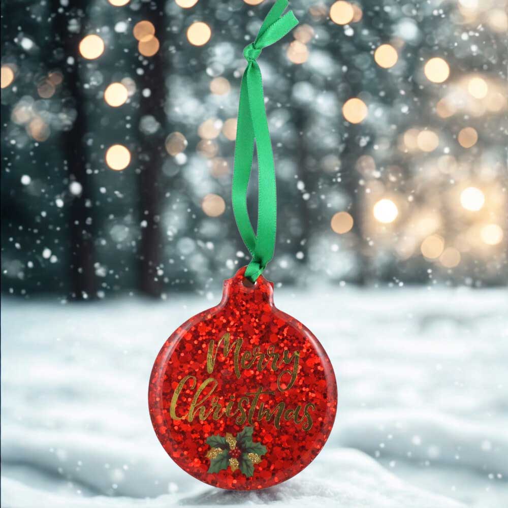 Red glittery Christmas ornament with 'Merry Christmas' text and green ribbon against a snowy forest background | Lilylin Designs