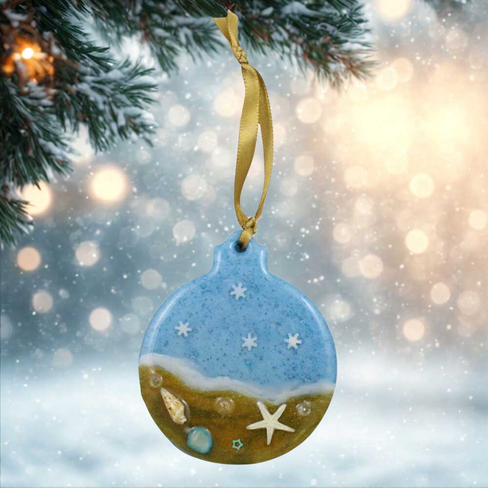 Decorative ornament with beach scene design hanging from a tree. | Lilylin Designs