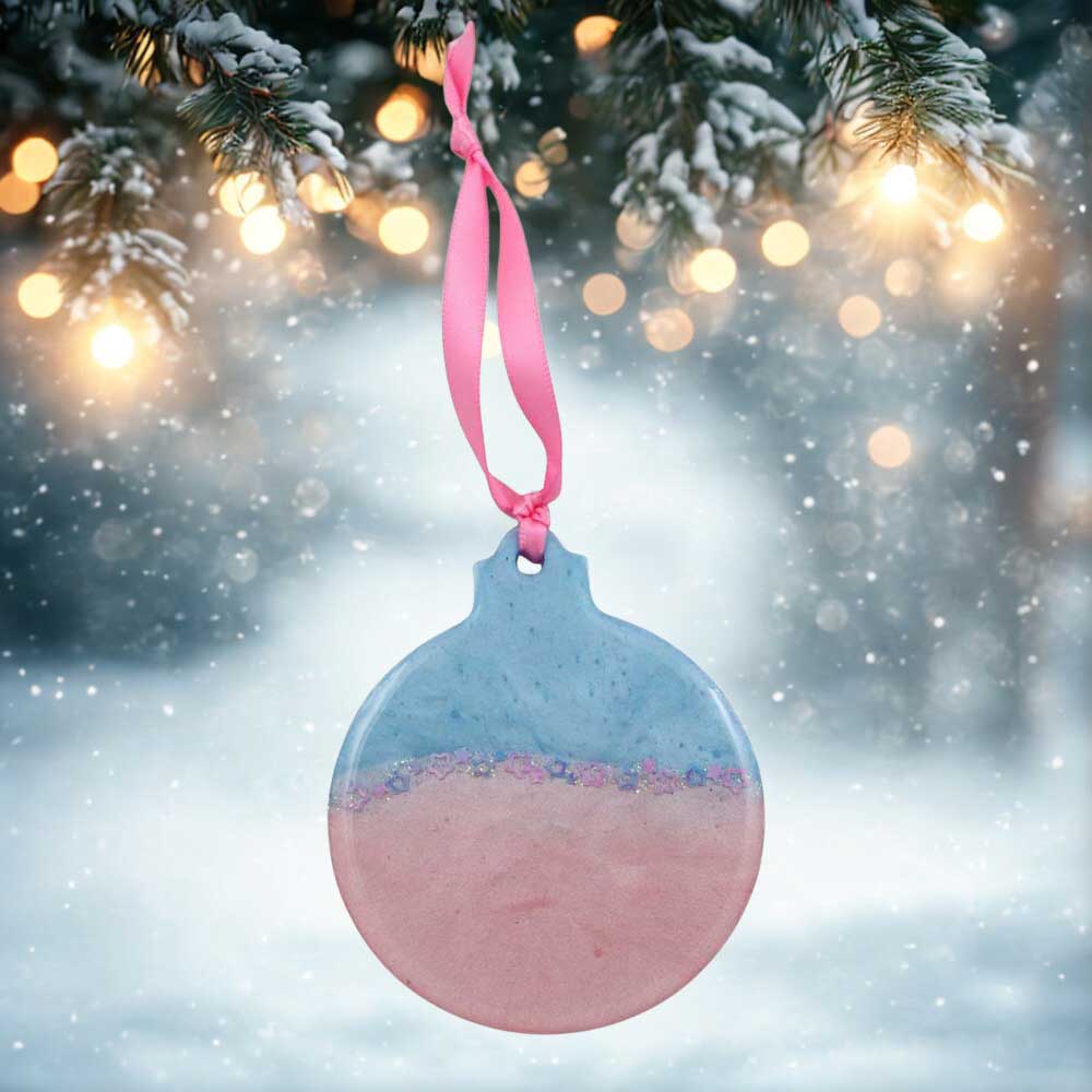 Decorative ornament with pink and blue gradient hanging from a tree branch with lights in the background | Lilylin Designs