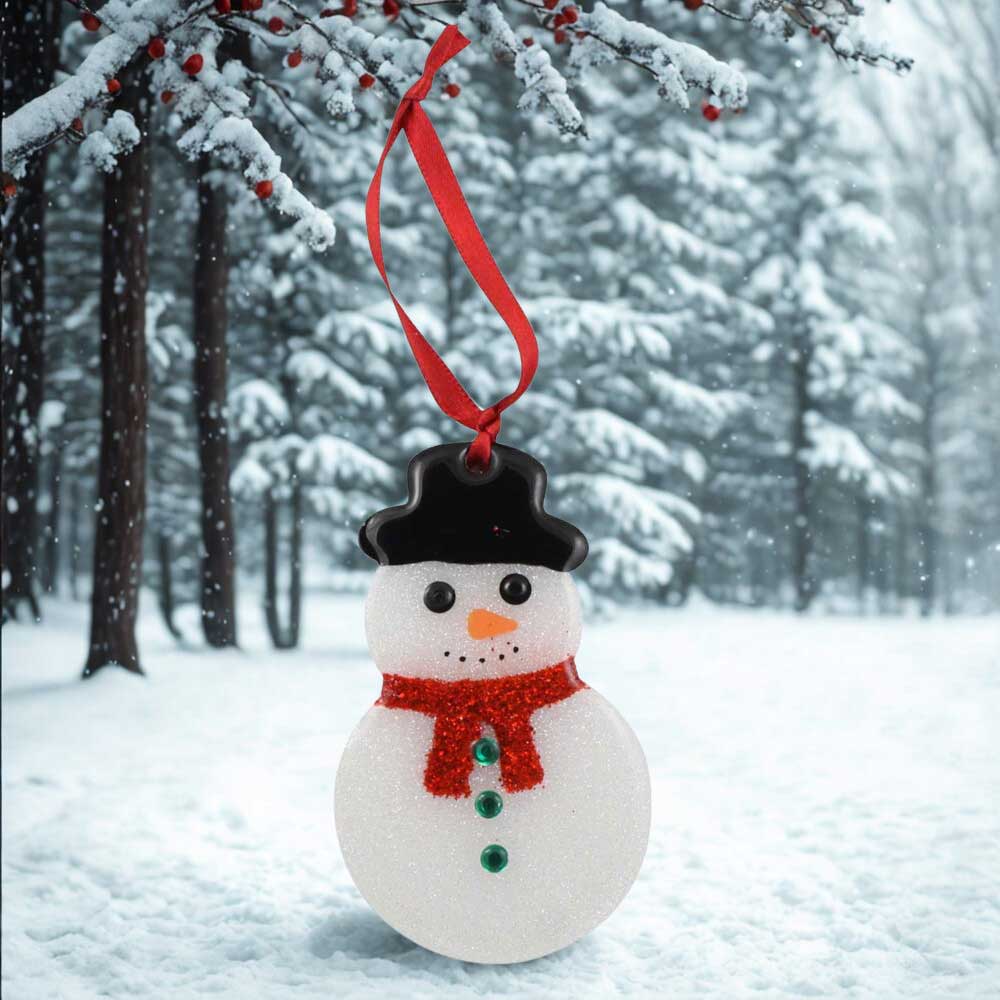Snowman ornament hanging from a tree in a snowy forest | Lilylin Designs