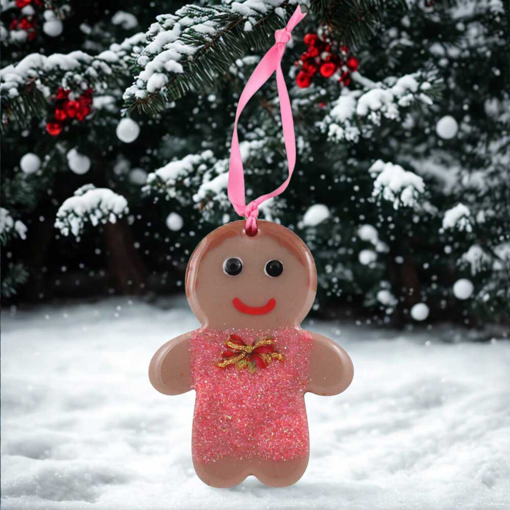 Decorative gingerbread girl ornament with pink dress and Christmas bow a snowy background | Lilylin Designs
