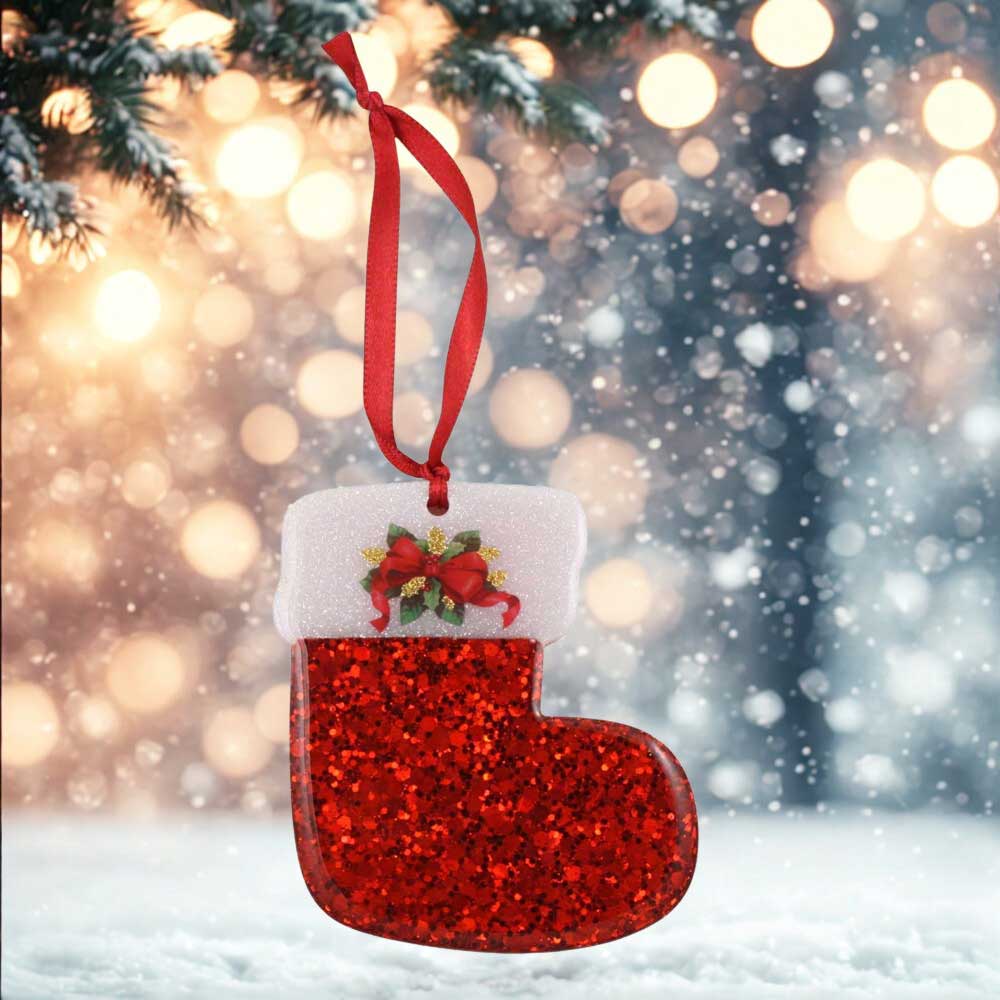 Red glittery Christmas stocking ornament with a white cuff and red ribbon against a festive background.| Lilylin Designs