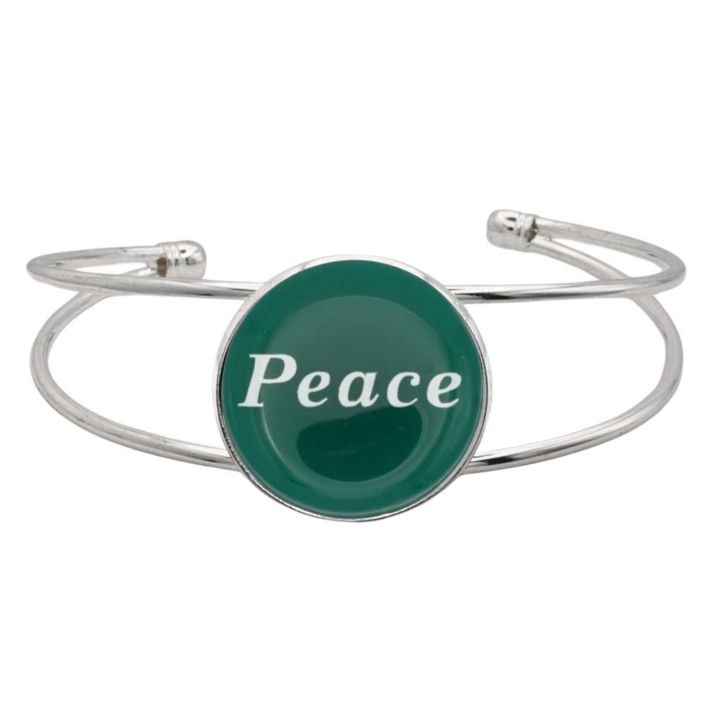 A silver-toned metal cuff bracelet featuring a round green disc with the word 'Peace' printed in white script, shown on a plain white background – Lilylin Designs