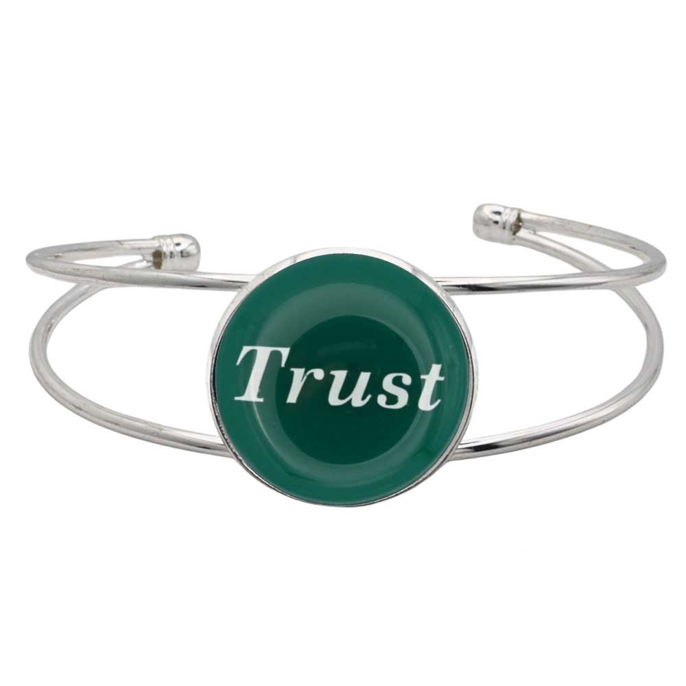 A silver-toned metal cuff bracelet featuring a round green disc with the word 'Trust' printed in white script, shown on a plain white background – Lilylin Designs