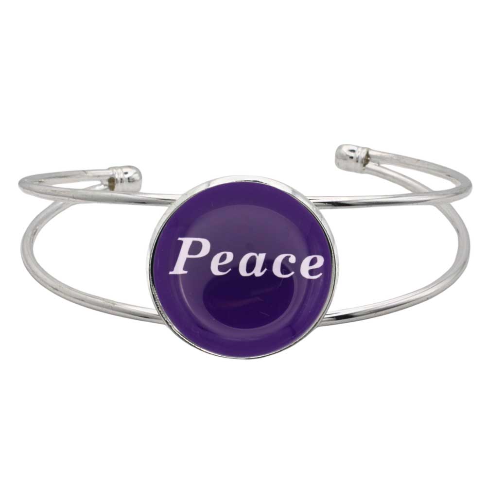 A silver-toned metal cuff bracelet featuring a round purple disc with the word 'Peace' printed in white script, shown on a plain white background – Lilylin Designs