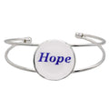 A silver-toned metal cuff bracelet featuring a round white disc with the word “Hope” printed in blue script, shown on a plain white background – Lilylin Designs