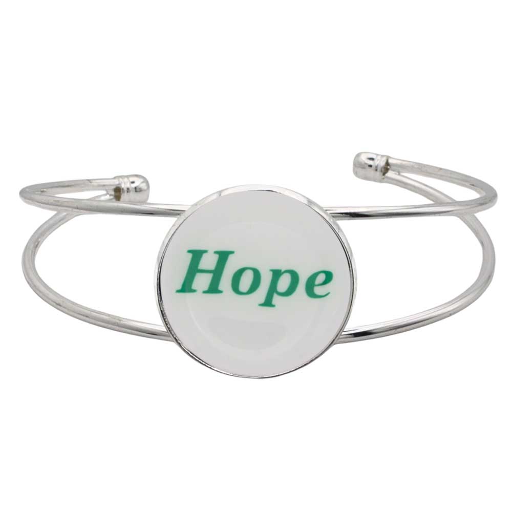 A silver-toned metal cuff bracelet featuring a round white disc with the word “Hope” printed in green script, shown on a plain white background – Lilylin Designs